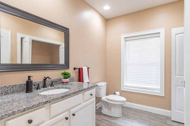 bathroom featuring wood-type flooring, vanity, and toilet