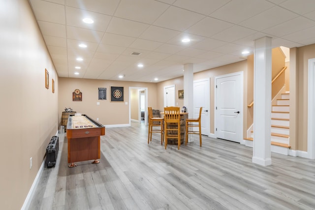 dining area featuring light wood-type flooring and a drop ceiling