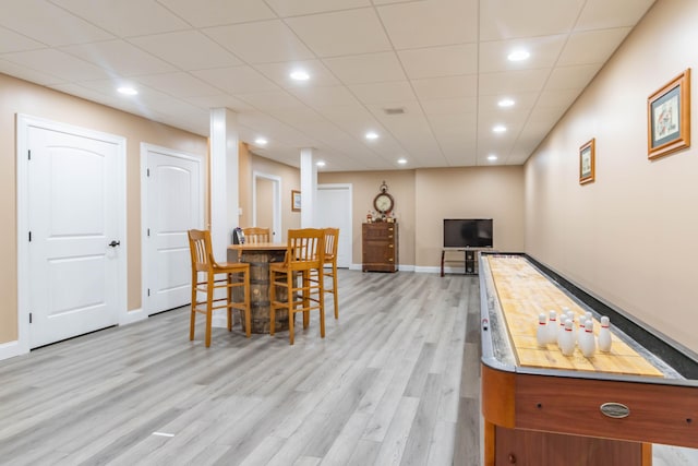 game room with a drop ceiling and light hardwood / wood-style flooring