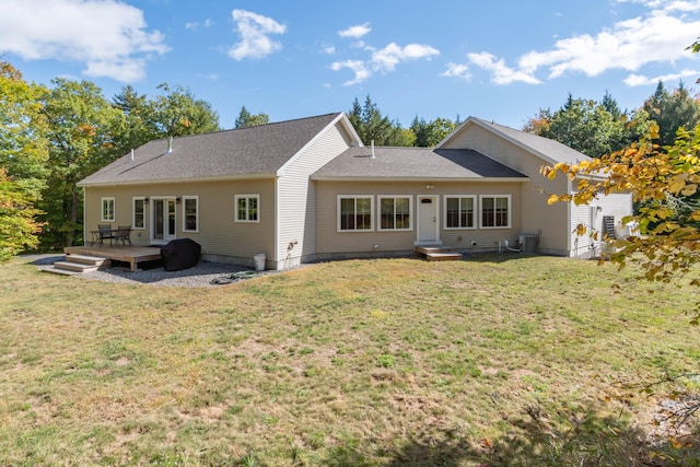 rear view of property featuring french doors, a wooden deck, and a yard