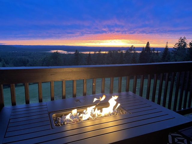 deck at dusk featuring an outdoor fire pit