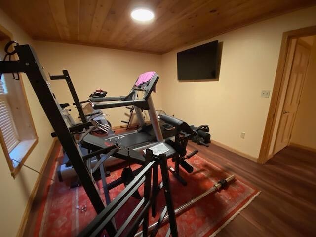 exercise room with wooden ceiling and dark hardwood / wood-style flooring