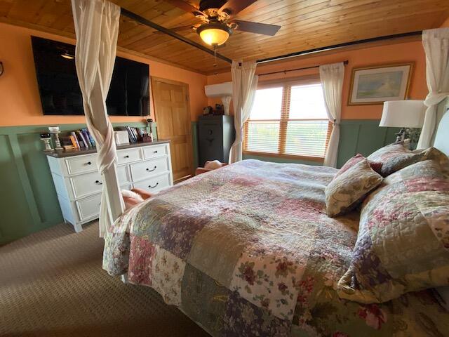 carpeted bedroom with ceiling fan and wooden ceiling