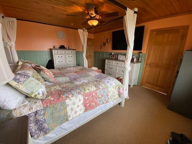 carpeted bedroom with crown molding, wood ceiling, and ceiling fan