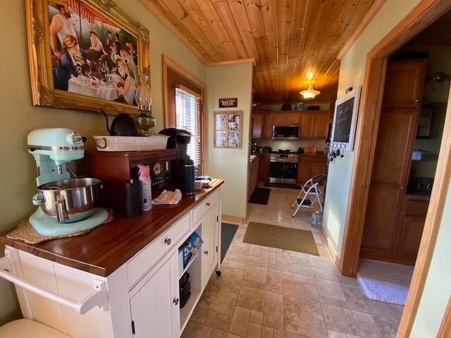 kitchen featuring white cabinets, stainless steel appliances, and wooden ceiling