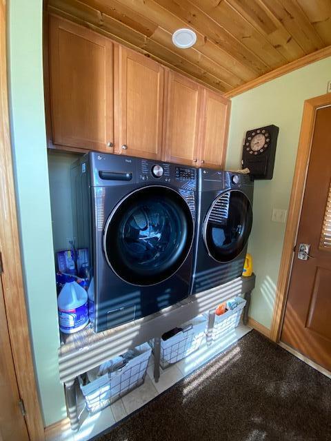 laundry room with separate washer and dryer, wooden ceiling, tile patterned floors, crown molding, and cabinets