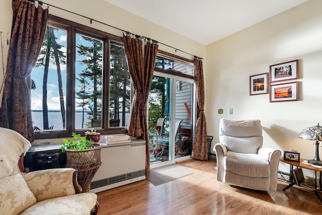 sitting room featuring a water view and light hardwood / wood-style flooring