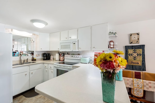 kitchen featuring white appliances, sink, decorative backsplash, light wood-type flooring, and white cabinetry