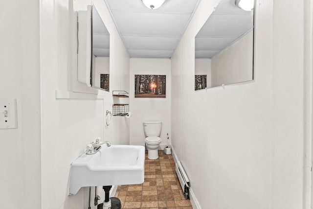 bathroom featuring sink, toilet, and a baseboard heating unit