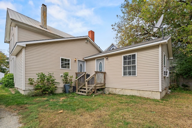 rear view of house featuring a lawn