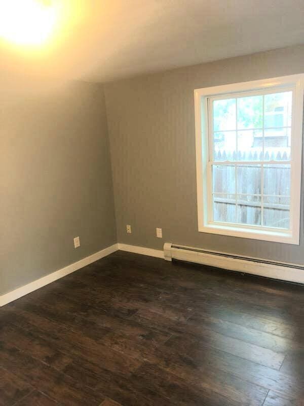 bonus room featuring a baseboard heating unit and dark hardwood / wood-style floors