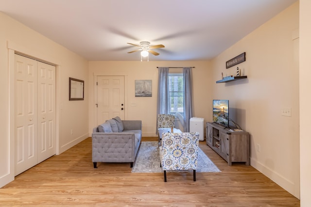 living area with ceiling fan and light hardwood / wood-style flooring