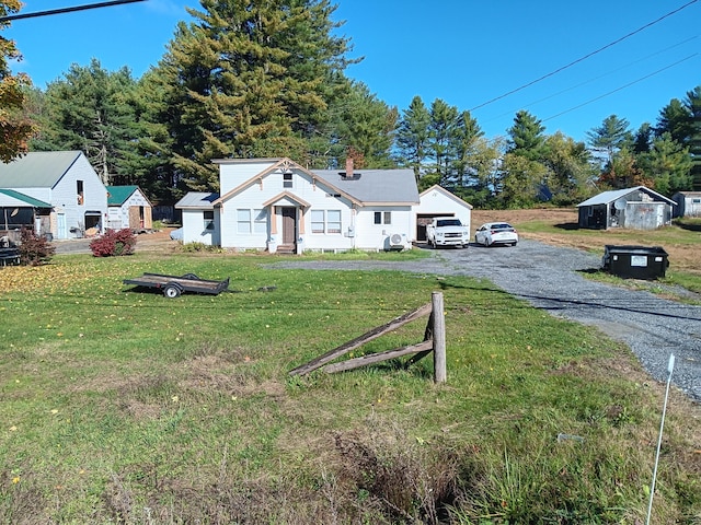 view of front of home with a shed and a front lawn