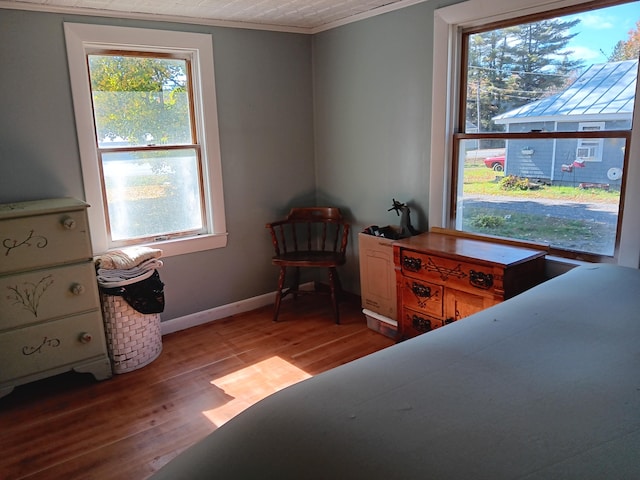 bedroom with ornamental molding and light hardwood / wood-style floors