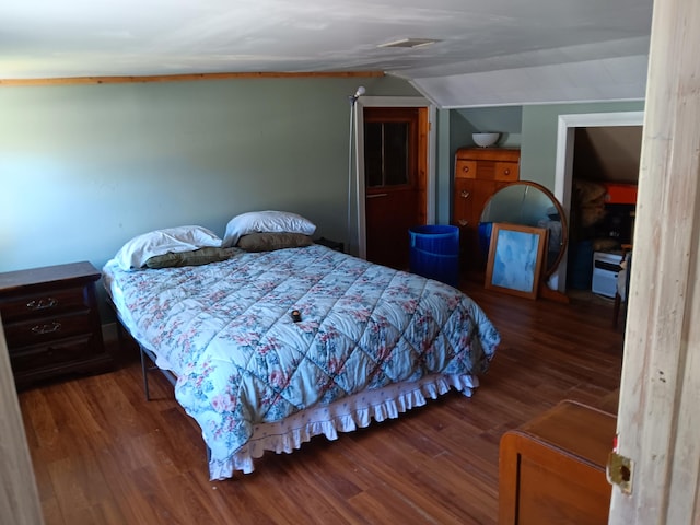 bedroom featuring dark wood-type flooring and vaulted ceiling