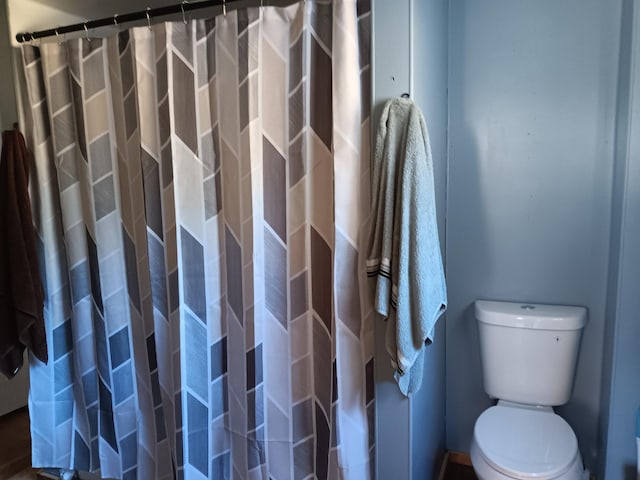 bathroom featuring a shower with curtain and toilet