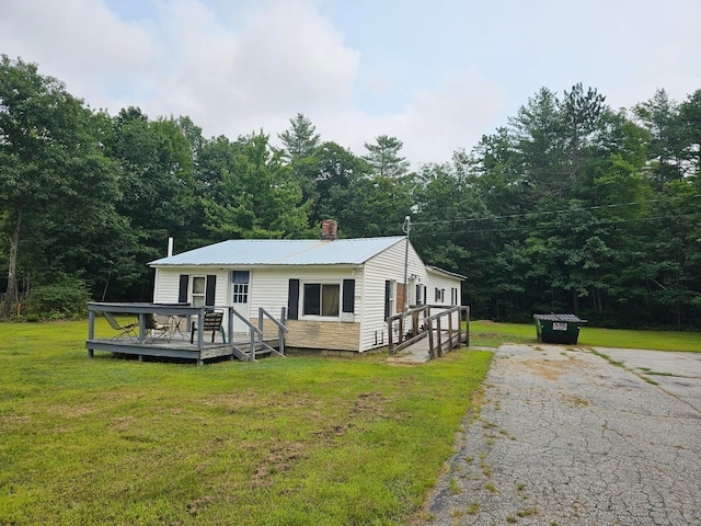 view of front facade featuring a front yard and a deck