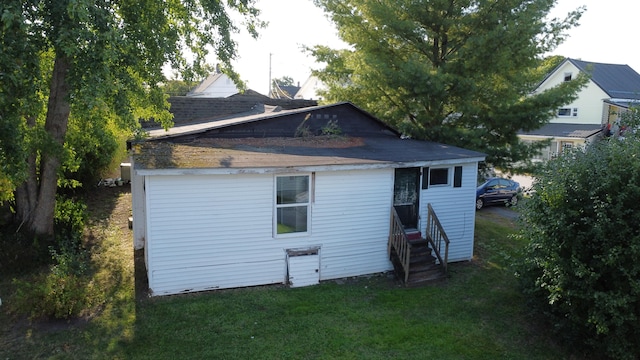 rear view of house featuring a lawn