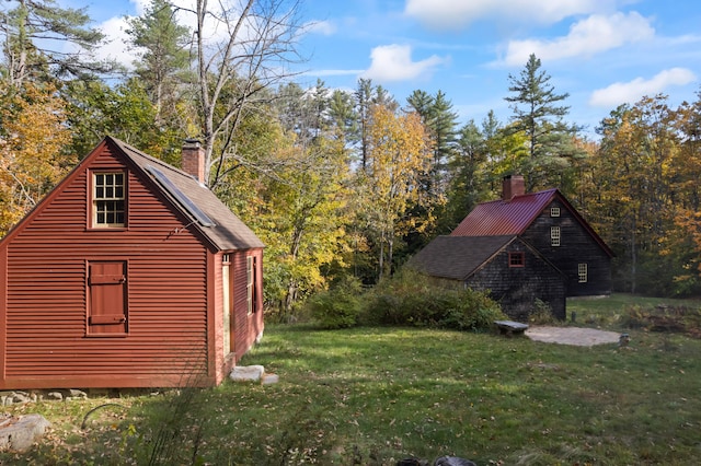 view of home's exterior with an outbuilding and a lawn