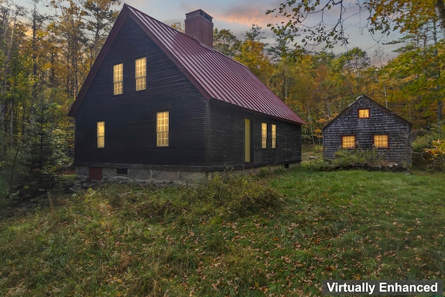 property exterior at dusk featuring a yard