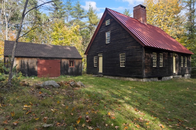 view of side of property with a yard and an outbuilding