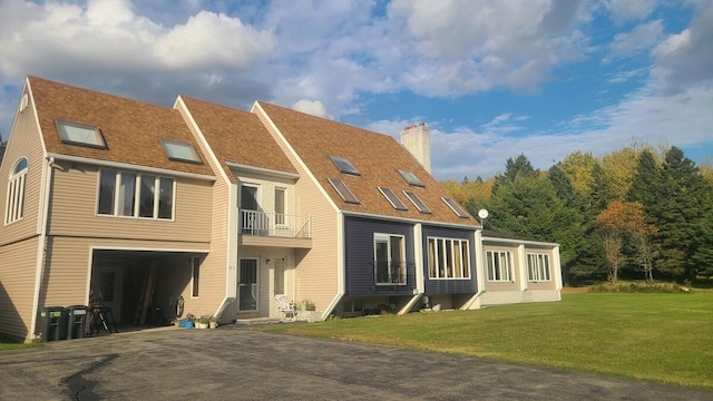 back of property featuring a balcony and a lawn