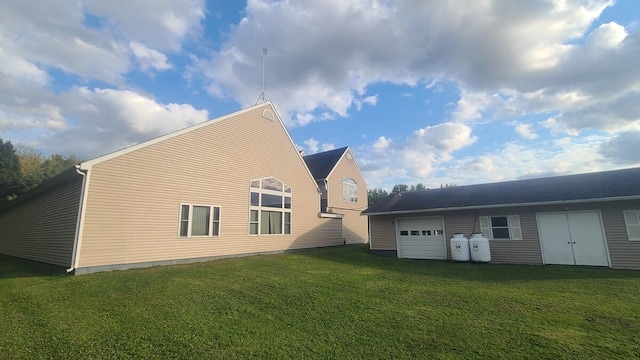 rear view of property featuring a yard and an attached garage