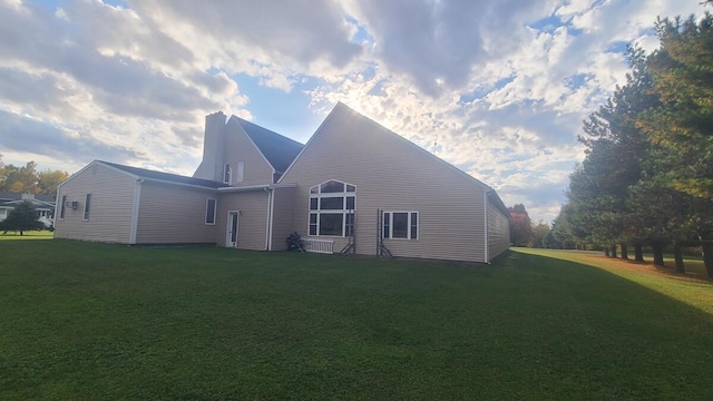 view of side of home with a yard and a chimney