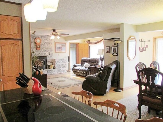 living room featuring a wealth of natural light, ceiling fan, a fireplace, and a wall mounted air conditioner