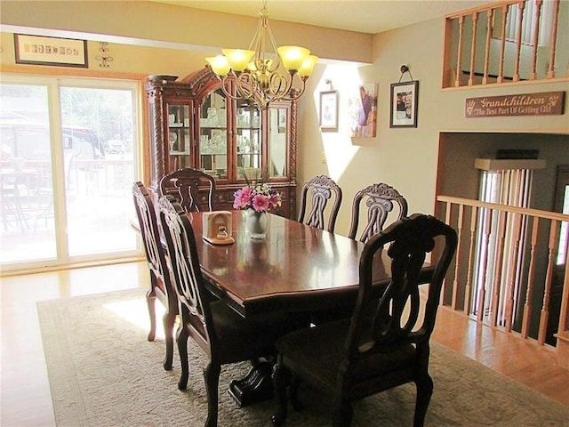 dining area with hardwood / wood-style floors and a notable chandelier