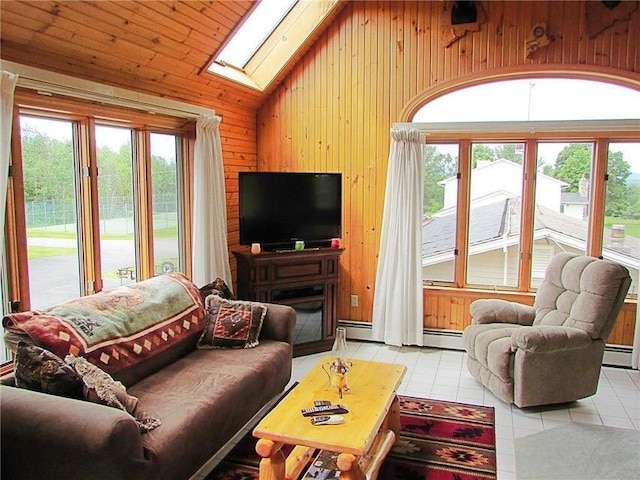 tiled living area with wooden walls, a baseboard radiator, and lofted ceiling with skylight