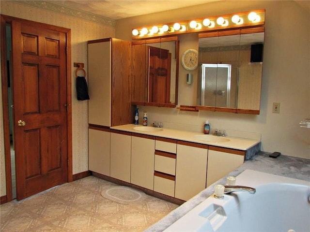 bathroom featuring a bath, tile patterned floors, double vanity, and a sink