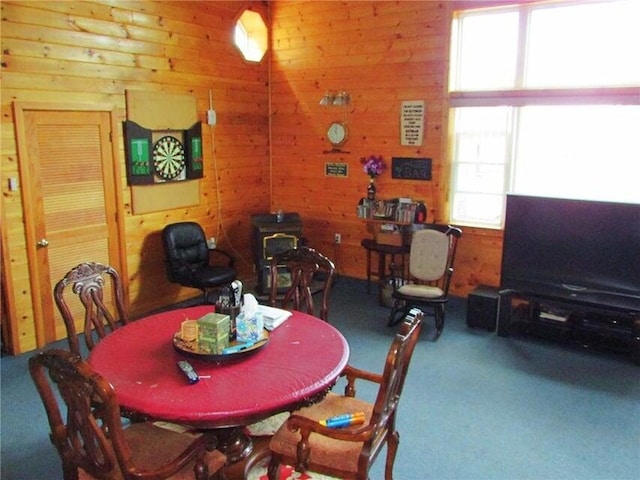 carpeted dining room with wood walls