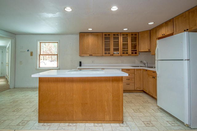 kitchen with white fridge, a kitchen island, and sink