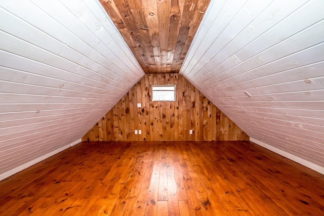 bonus room with lofted ceiling, wood-type flooring, wooden walls, and wooden ceiling