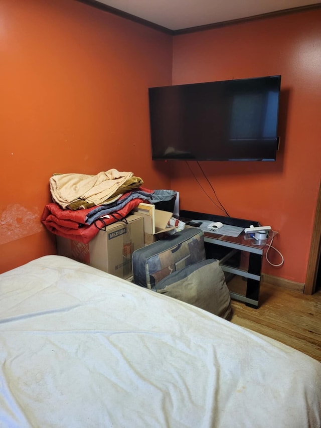 bedroom featuring wood-type flooring and ornamental molding