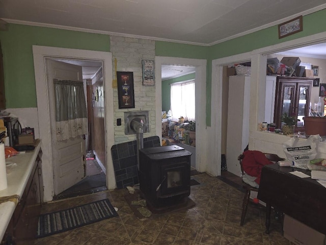 interior space with crown molding and a wood stove