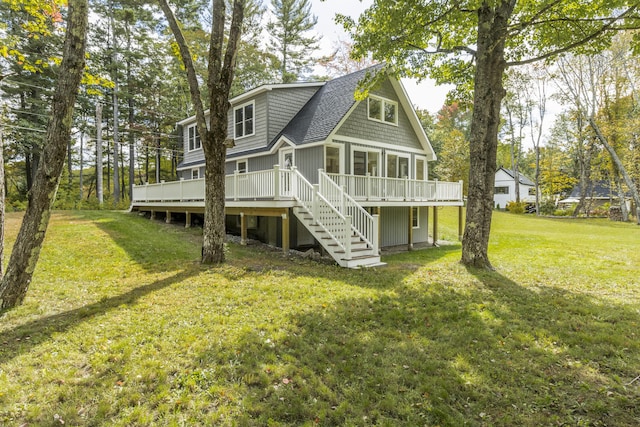 rear view of property with roof with shingles, stairs, a wooden deck, a sunroom, and a yard