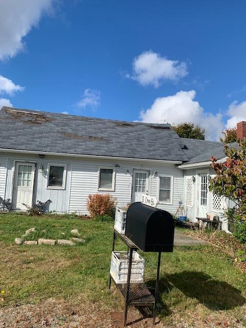 rear view of house featuring a yard