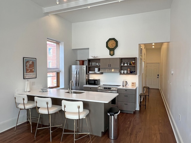 30 Water St, Ellsworth, ME 04605 - kitchen with kitchen peninsula, appliances with stainless steel finishes, a kitchen breakfast bar, dark wood-type flooring, and sink