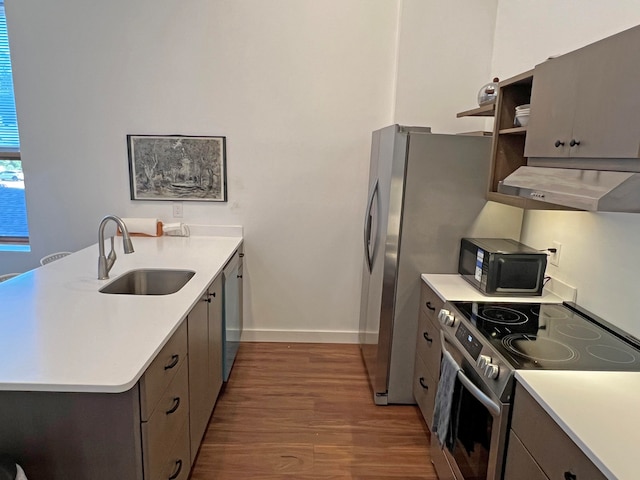 30 Water St, Ellsworth, ME 04605 - kitchen with dark wood-type flooring, kitchen peninsula, stainless steel appliances, range hood, and sink