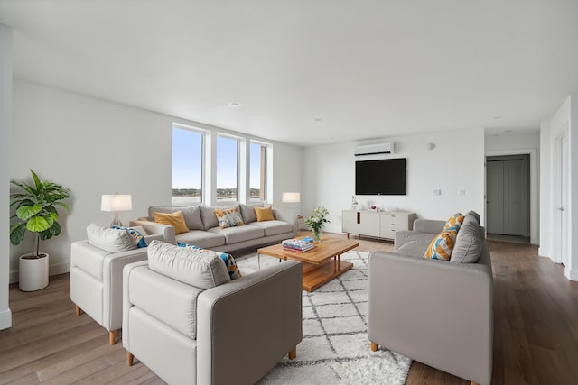 living room with an AC wall unit and light hardwood / wood-style flooring