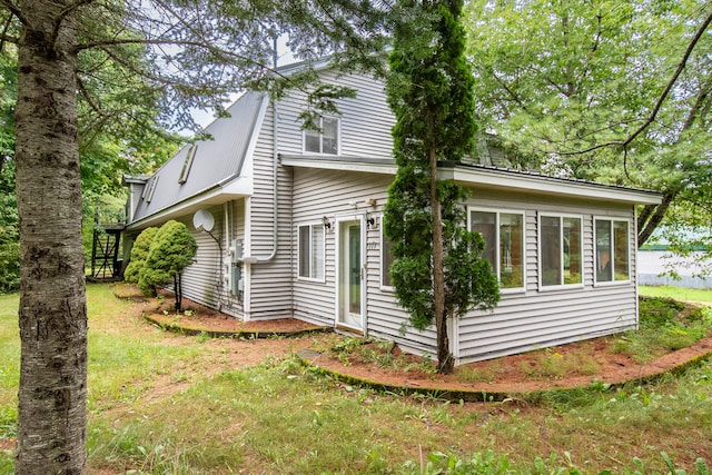 view of property exterior with a lawn