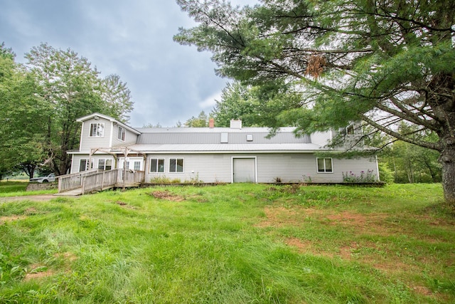 rear view of property with a wooden deck and a lawn