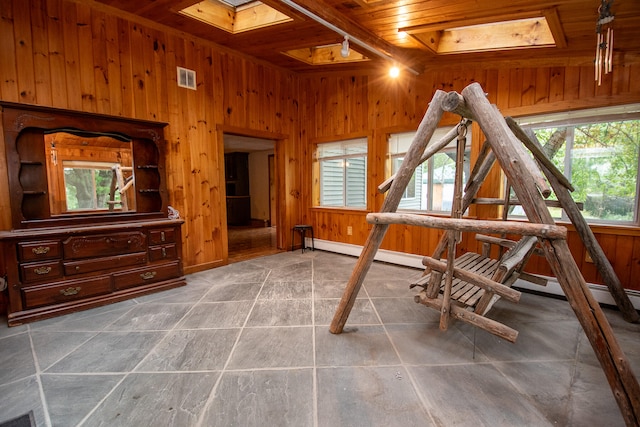 misc room featuring a skylight, wood ceiling, and a wealth of natural light