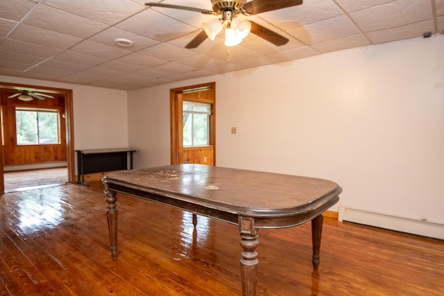 game room featuring hardwood / wood-style floors, a baseboard heating unit, and ceiling fan