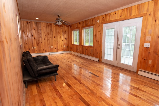 sitting room with light wood-type flooring, plenty of natural light, wood walls, and wooden ceiling