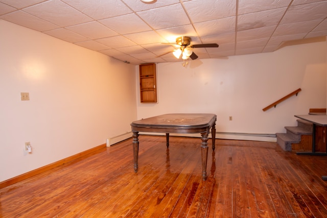 rec room featuring ceiling fan, hardwood / wood-style flooring, and a baseboard heating unit