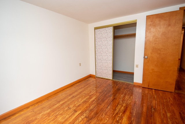 unfurnished bedroom with a closet and hardwood / wood-style floors