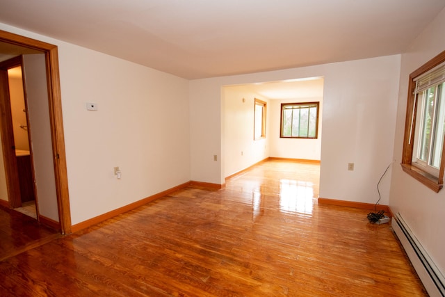 unfurnished room featuring light hardwood / wood-style floors and baseboard heating